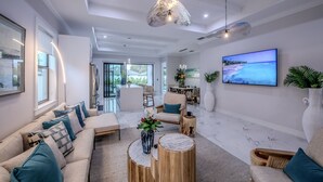 Ein modernes Wohnzimmer mit einer Couch, einem Couchtisch und einem an der Wand befestigten Fernseher.