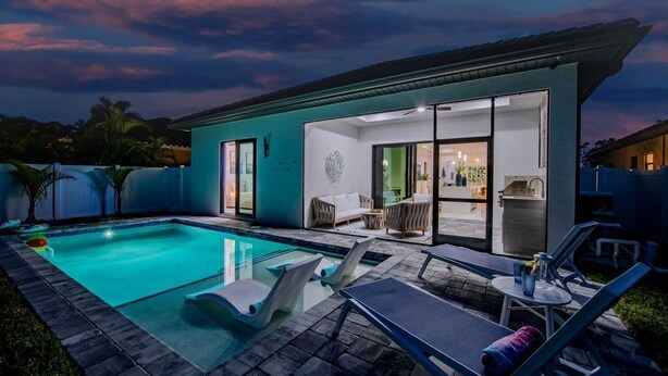 Ein modernes Haus mit Swimmingpool, Außenbereich und einer Terrasse.