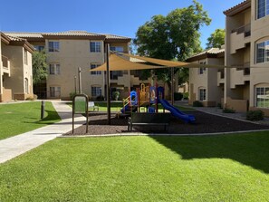 Children can play safely on the slide and climbing structure in this well-maintained outdoor play area.