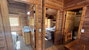 A wooden cabin interior with a bathroom, a bed, and a dining area. - Beautiful 2 Bedroom Cabin on Taylor River with Private Hot Tub (Almont)