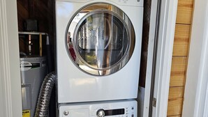 Eine übereinander gestellte Waschmaschine und ein Trockner in einer Garage.