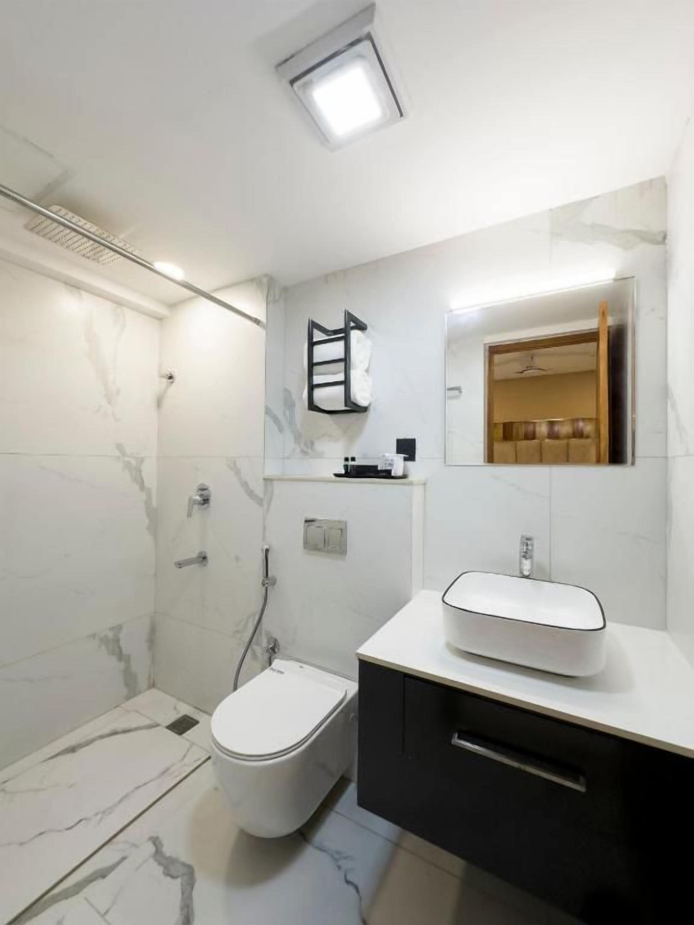 A modern bathroom with a toilet, sink, and shower.