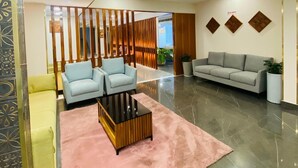 A modern lobby with a seating area, a decorative wall, and a plant. - 7 Apple Hotel Guruvayur, Kerala (Chavakkad)