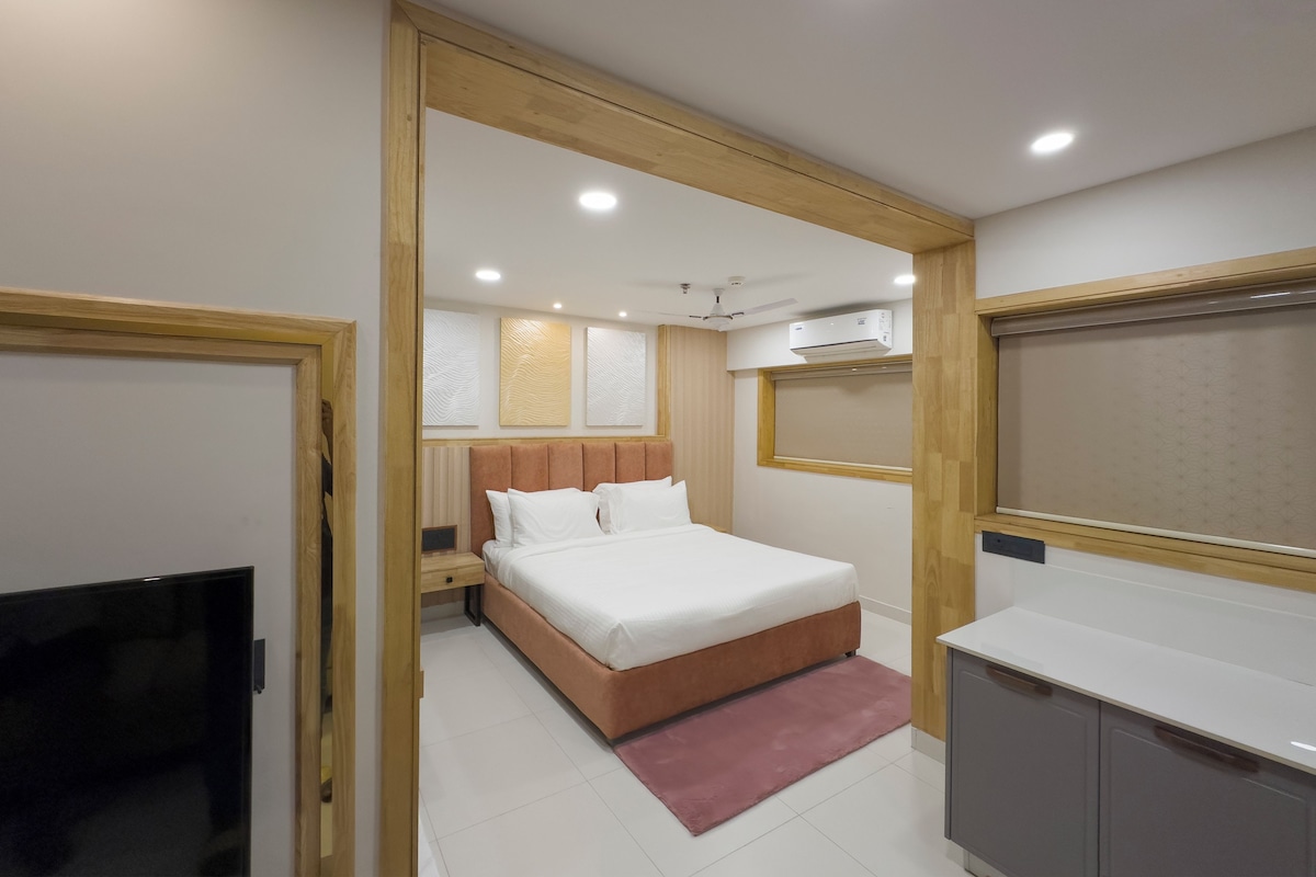 A modern bedroom with a bed, bedside table, and a TV.