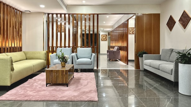 A modern lobby with a sofa, armchairs, a coffee table, and a decorative partition. - 7 Apple Hotel Guruvayur, Kerala (Chavakkad)