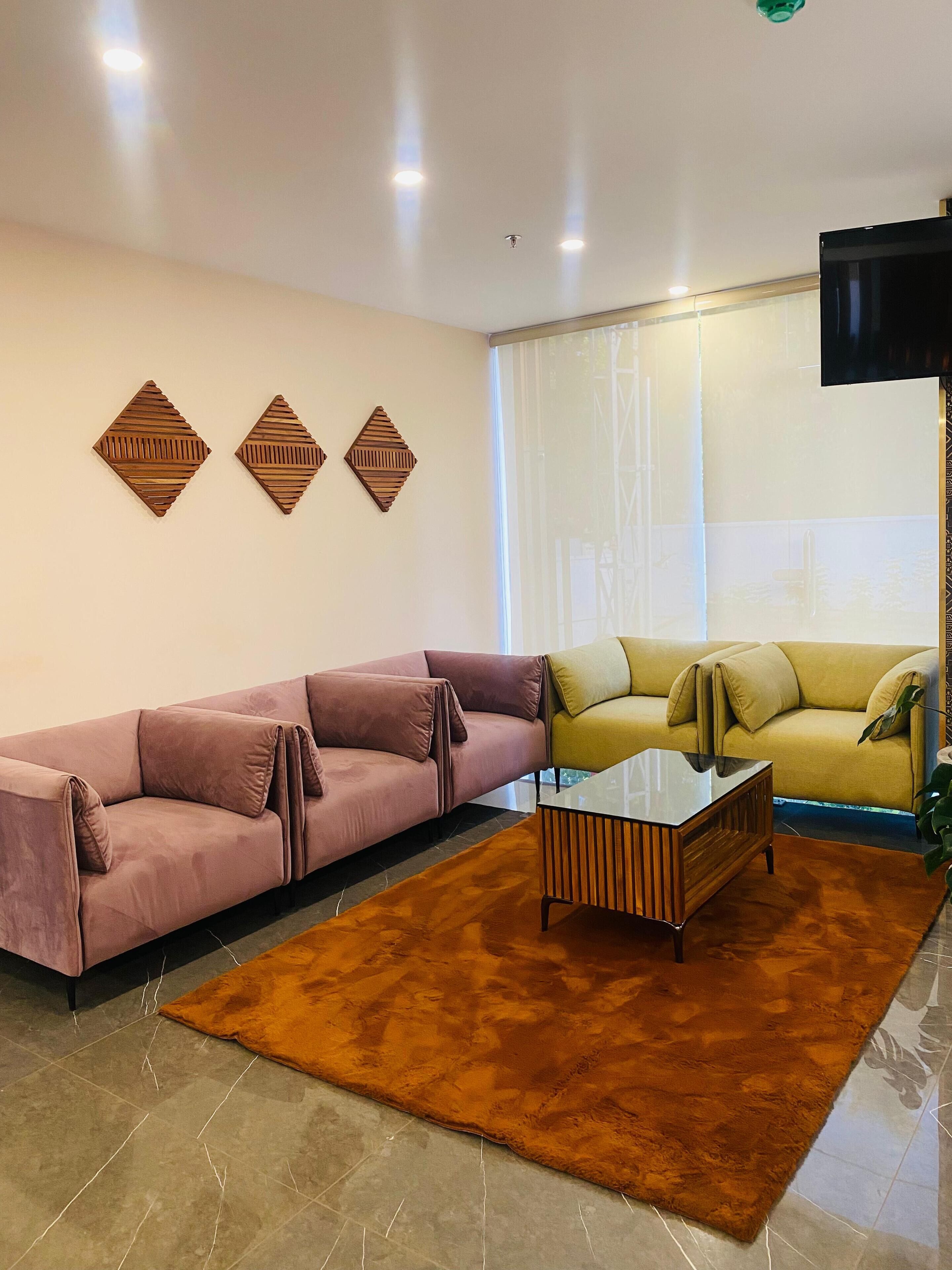 Una sala moderna con un sofá seccional, una mesa de centro y decoración en la pared.