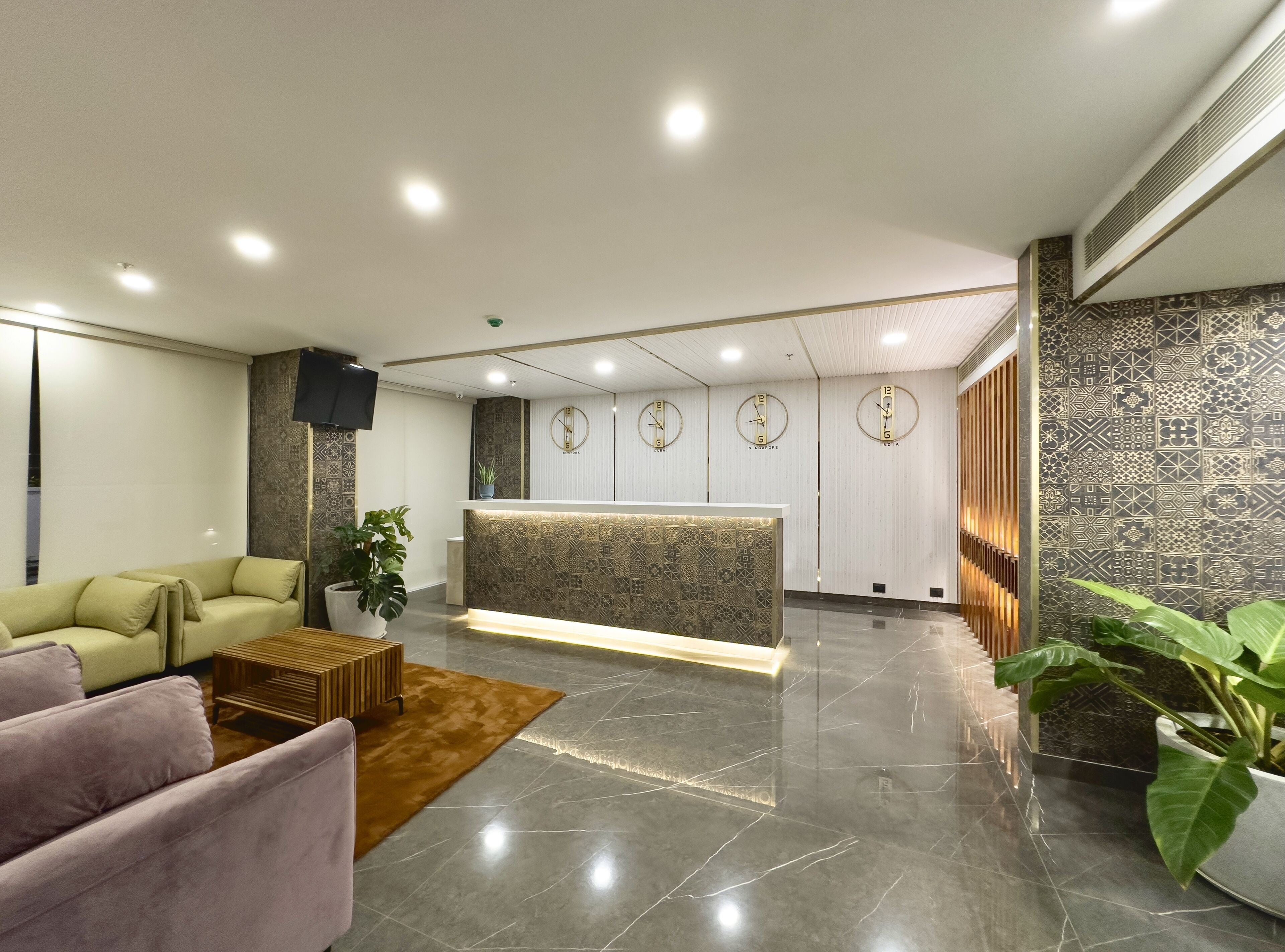 A modern reception area with a marble floor, a reception desk, and a seating area with sofas.