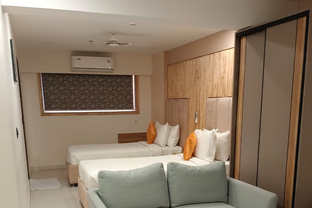 A modern bedroom with a bed, a sofa, and a wardrobe.