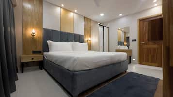 Ein modernes Schlafzimmer mit einem großen Bett, Holzwandverkleidung, einem Deckenventilator und einer Holztür.