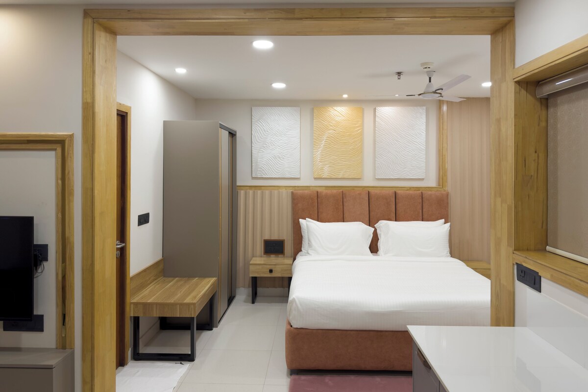 A modern bedroom with a bed, bedside tables, a bench, a wardrobe, and a ceiling fan.