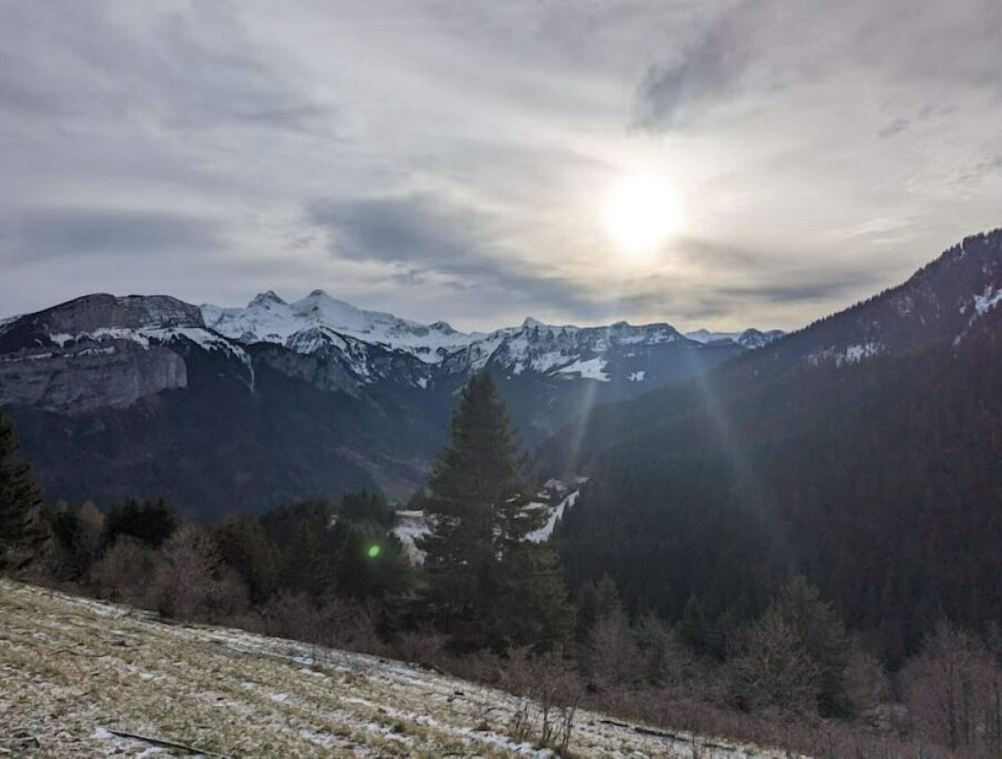 Een bergachtig landschap met besneeuwde toppen en een dal.