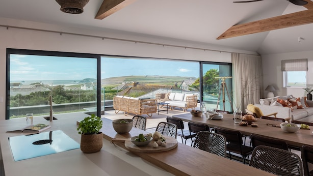 Uma cozinha moderna com uma ilha grande, um espaço de refeições com vista e uma área de estar aconchegante com vista.