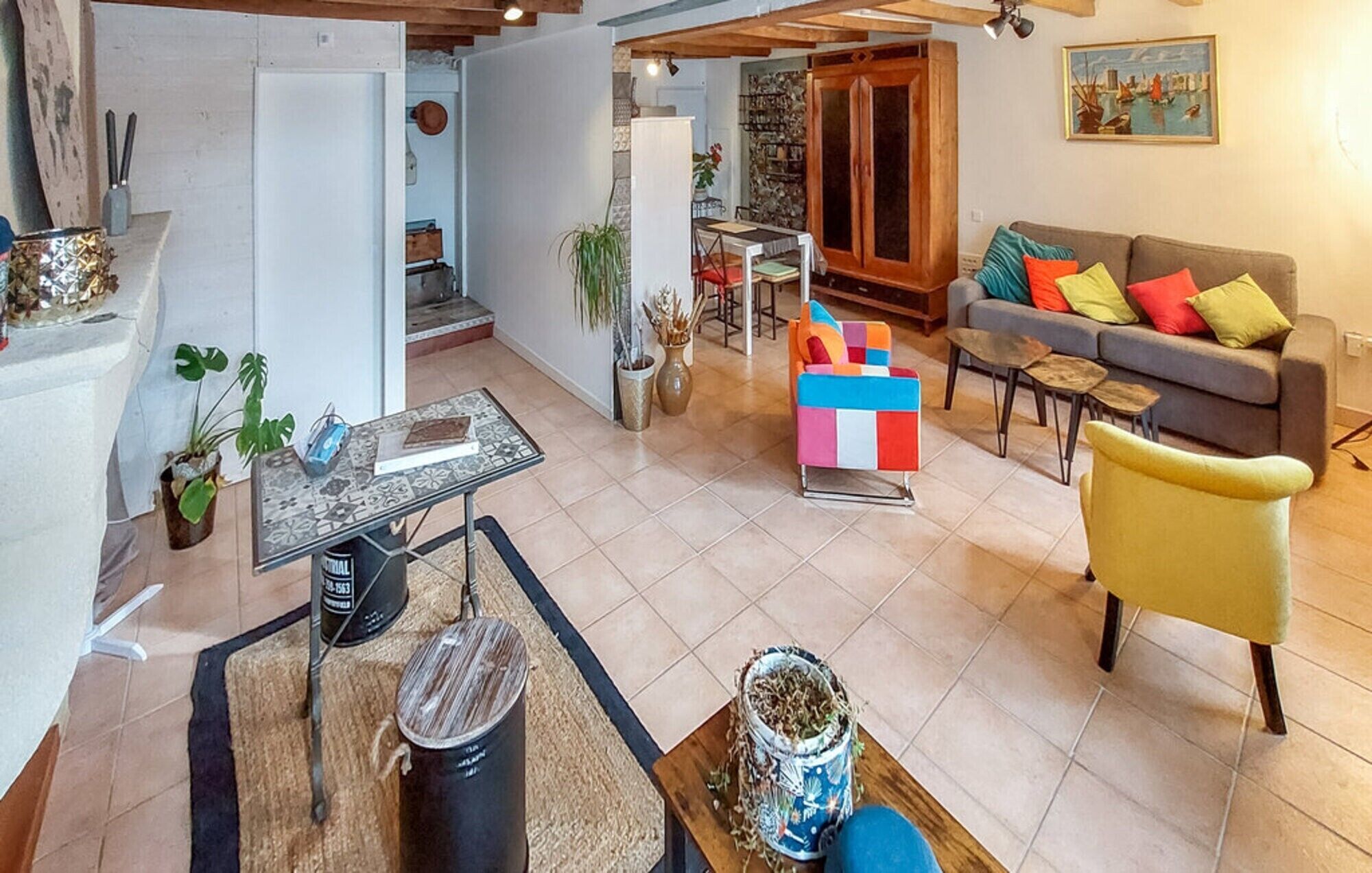 A modern living room with a sofa, a coffee table, and a dining area with a table and chairs.