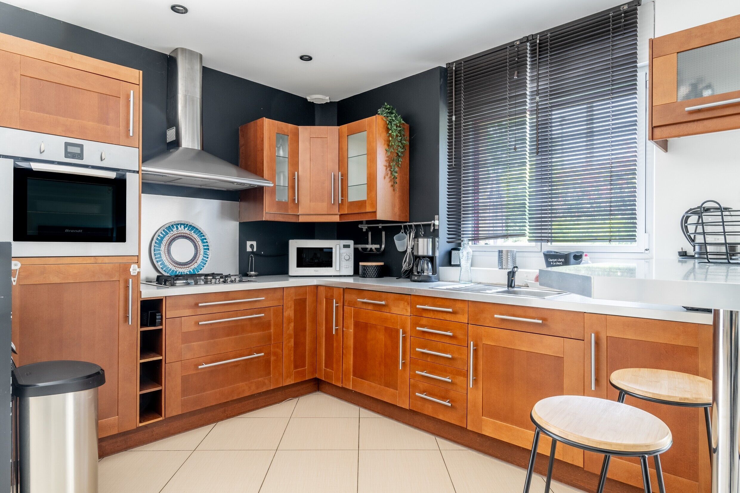 Une cuisine moderne avec des meubles en bois, un four à micro-ondes, une cuisinière et un évier.