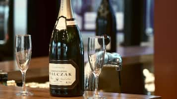 A bottle of Champagne Christophe Walczak on a bar counter with two glasses.