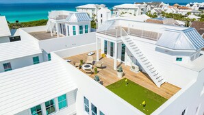 A modern white building with a rooftop patio, a pool, and a view of the ocean. - Official 30A Show House with Private Pool, Elevator, Putt Putt, Private Beach (Rosemary Beach)