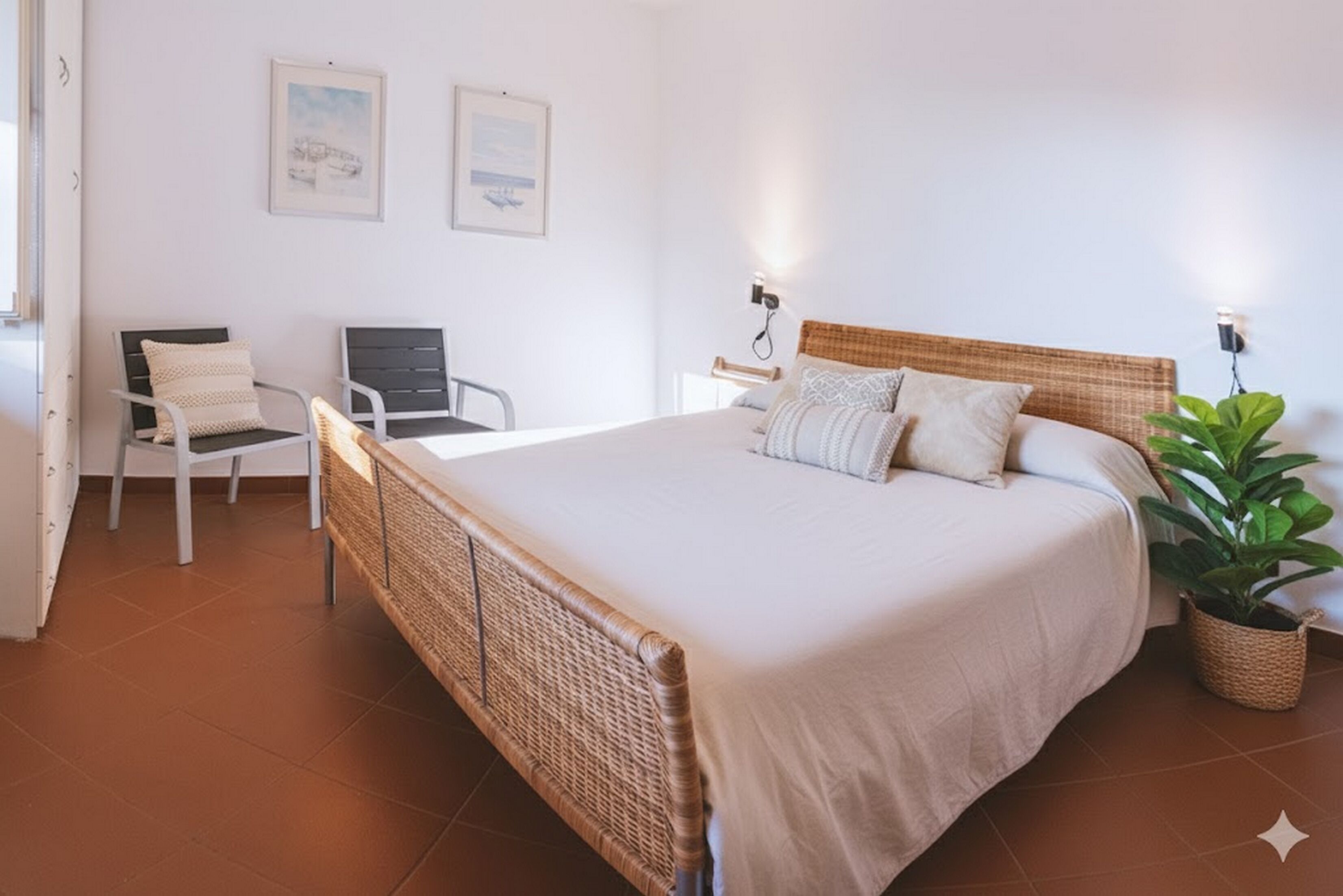 Un dormitorio con una cama grande, una silla, un escritorio y una planta en maceta.
