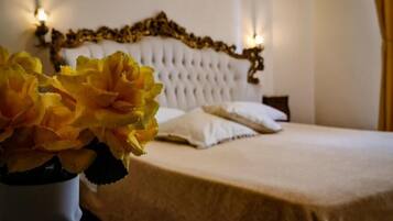 A neatly made bed with a white headboard and two bedside lamps.
