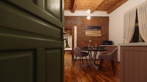 Un coin repas avec un mur en briques, un plancher en bois et un tableau accroché au-dessus de la table.