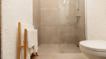 A bathroom with a shower, toilet, and towel rack.