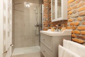 Superior studio | Badkamer | Een douche, een haardroger, pantoffels, handdoeken