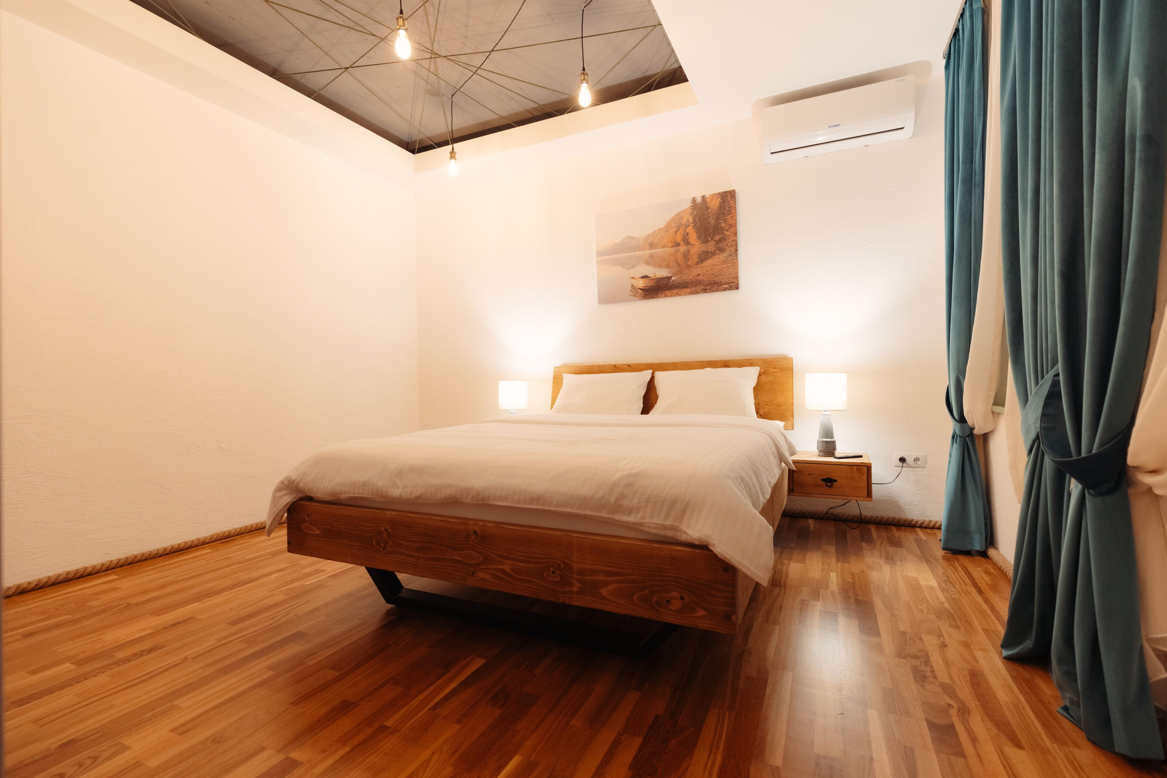 Ein Schlafzimmer mit einem hölzernen Bett, einem Nachttisch, einer Wand-Klimaanlage und einer Deckenleuchte.
