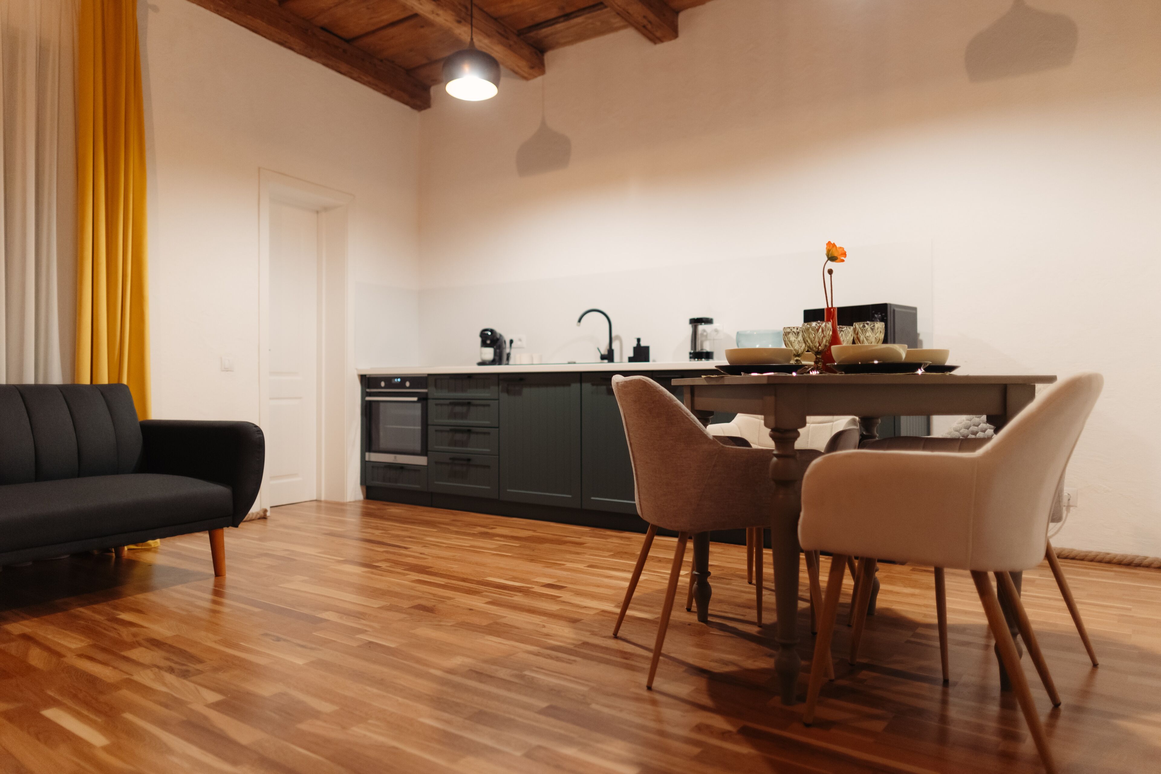 Una cocina moderna con armarios oscuros, una mesa de comedor de madera y dos sillas.