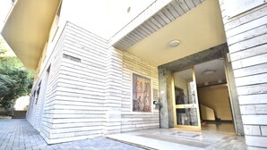 A building with a tiled entrance and a framed artwork above the door.