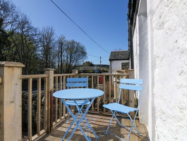 A wooden deck with a blue table and two blue chairs. - Gun Powder Cottage (Tighnabruaich)