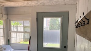 Un cuarto de lavandería con lavadora, secadora y una puerta con ventanal.