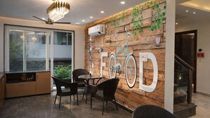 Un intérieur moderne comprenant un coin repas, un lustre et une illustration de vélo accrochée au mur.