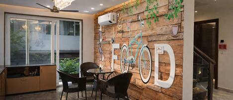 Un interior moderno con comedor, una araña y una ilustración de bicicleta colgada en la pared.