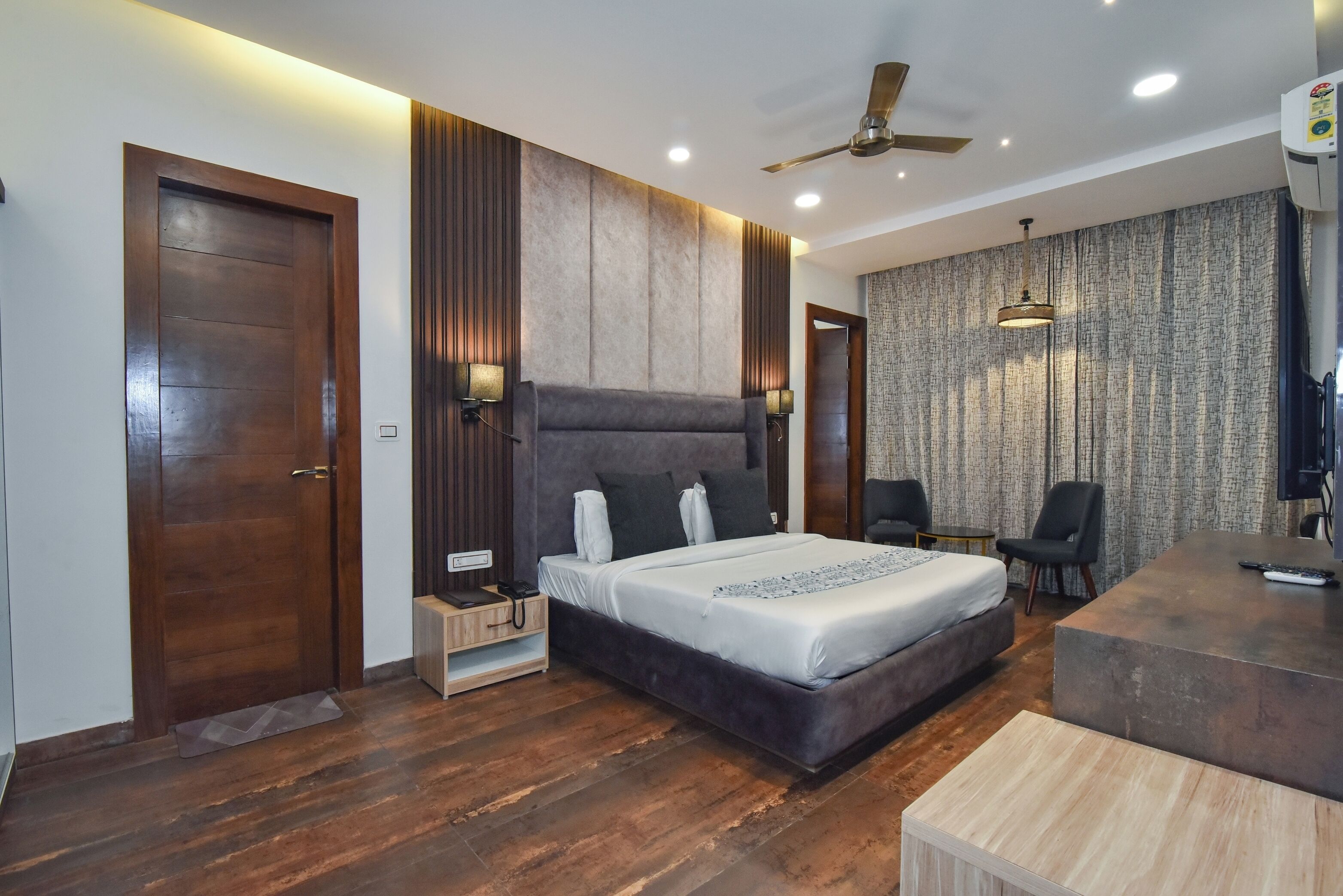 Un dormitorio moderno con una cama grande, un escritorio y una silla.