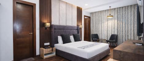 A modern hotel room with a large bed, a desk, and a chair.