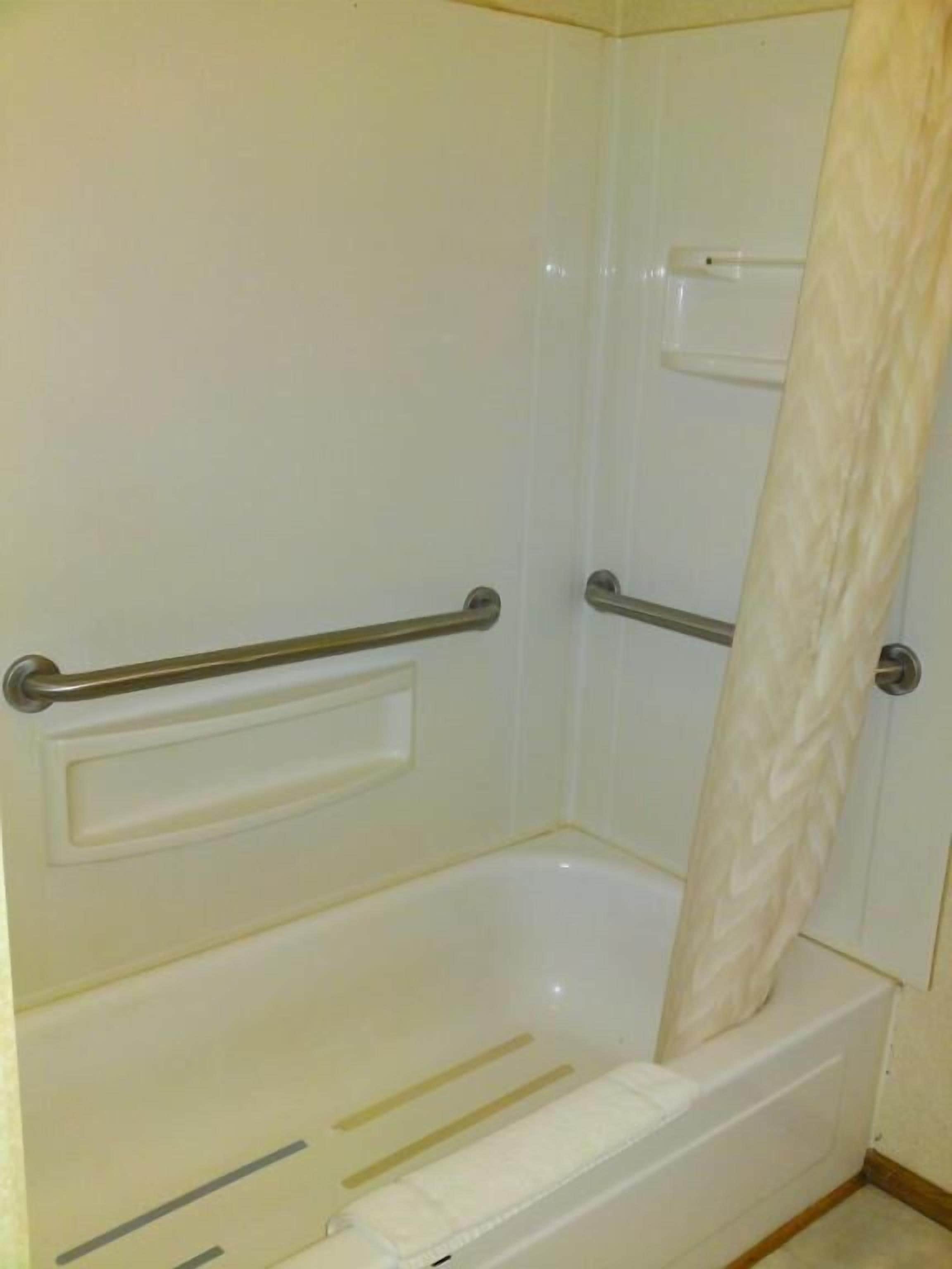A bathroom with a bathtub, a shower area, and a toilet.
