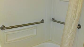 A bathroom with a bathtub, a shower area, and a toilet.