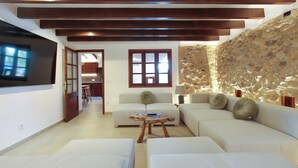 Amplia sala de estar con una pared de acento de piedra, un amplio sofá y una mesa de centro de madera.