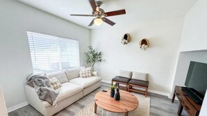 Ein modernes Wohnzimmer mit Sofa, Couchtisch und TV-Schrank.