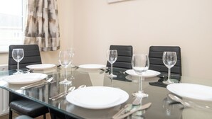 A dining table set for six with black chairs, white plates, and wine glasses. - Newly refurbed 5 bed house with Free Parking n Dryer (Birmingham)