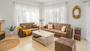 A living room with two sofas, a coffee table, and a small side table. - Maela Luxury Suite (Hersonissos)