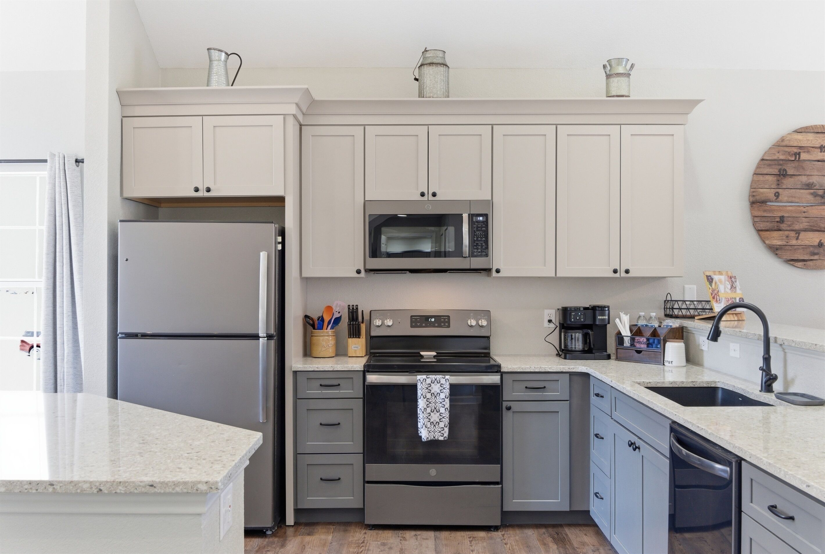 A modern kitchen with a stainless steel refrigerator, a built-in microwave, and a gas stove.