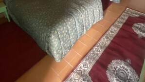 A room with two beds, a patterned rug, and a wall decoration. - Auberge des Cascades  (Imouzzer Ida Ou Tanane)