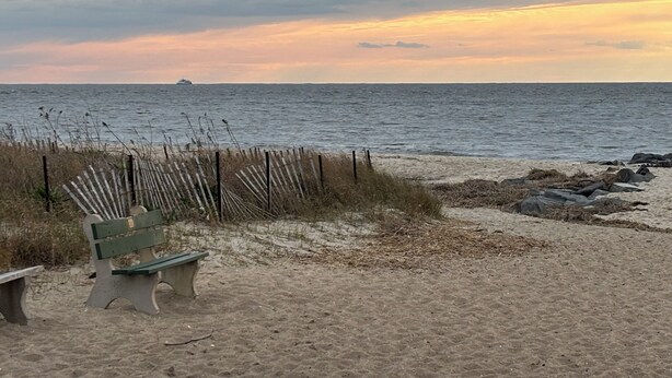 A beach with a bench, a fence, and a ship in the distance. - Cape May Home in Newest Hot Spot: Centrally Located, Family Friendly, Sleeps 12! (Cape May)