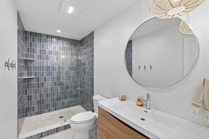 Un baño moderno con ducha, inodoro y lavamanos.