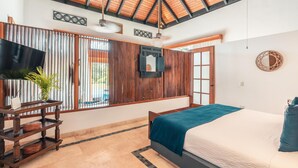 A bedroom with a bed, a TV, a wooden table, and a window with blinds. - Bungallow With Private Backyard and Pool (Punta Cana)