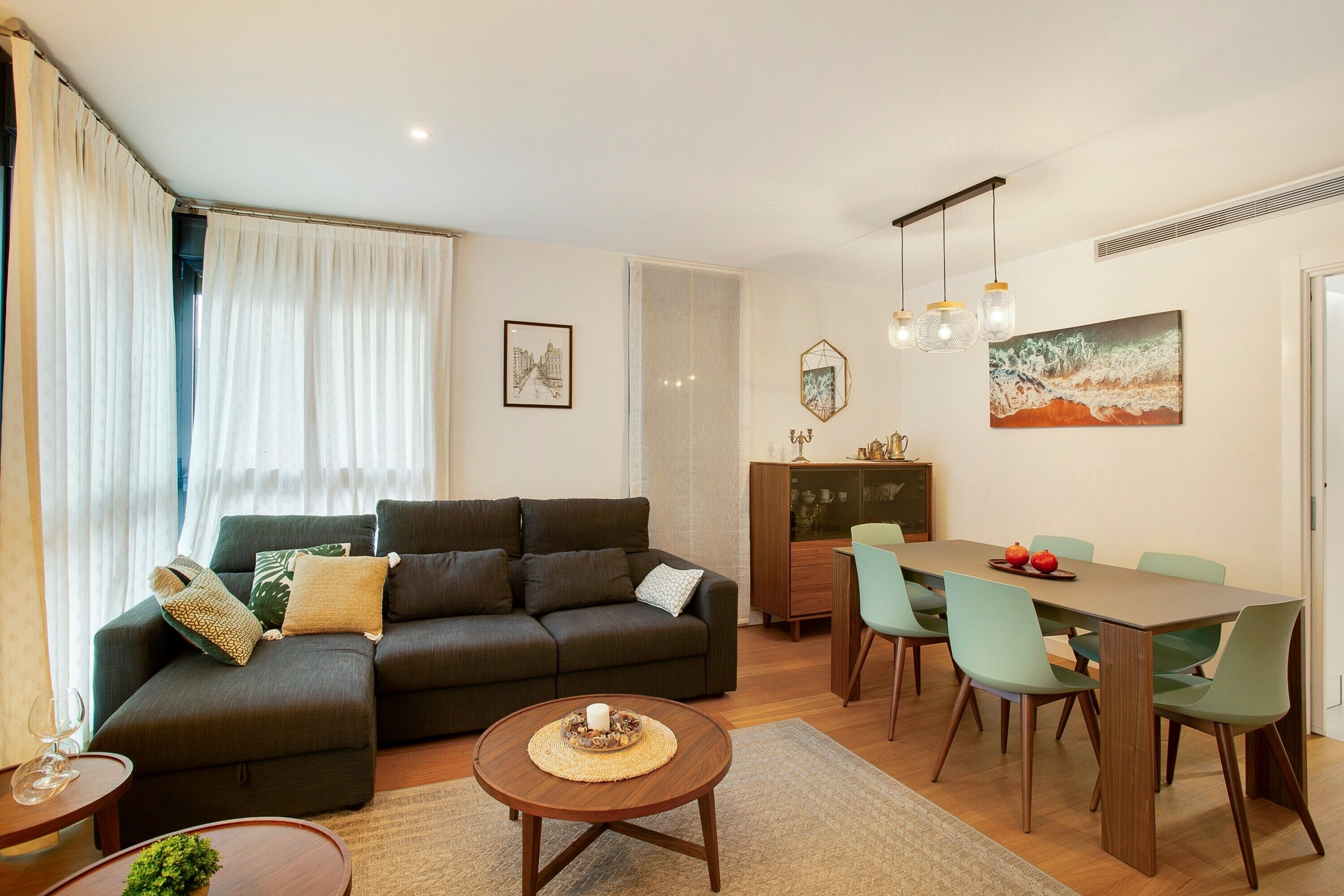 A living room with a sofa, dining table, chairs, and a coffee table.