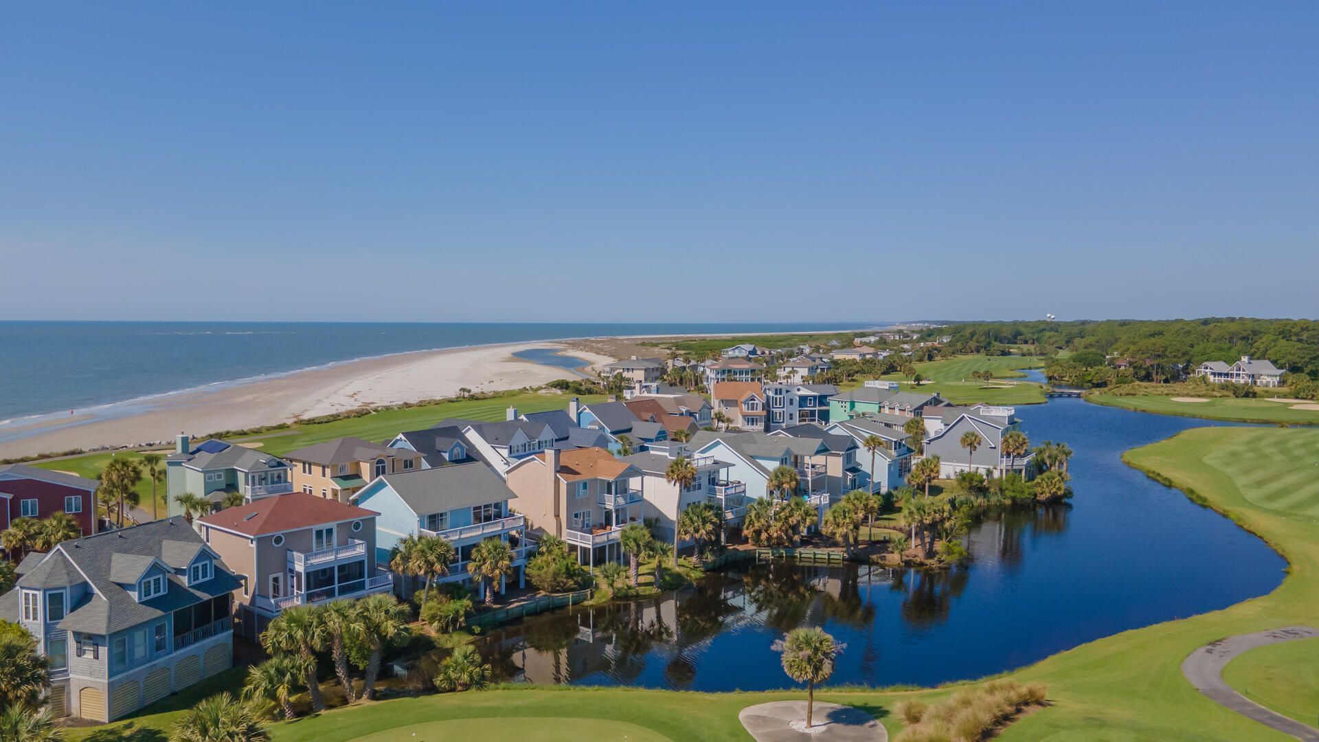 A residential area with houses, a beach, and a body of water.