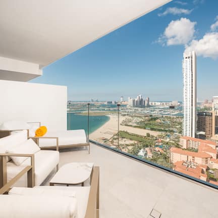 A balcony with a city view, including a beach and high-rise buildings.
