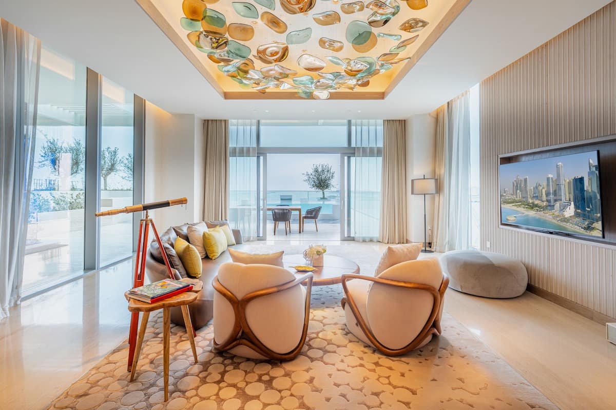 Una sala moderna con un televisor grande, asientos cómodos y vistas a la ciudad.