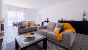 A modern living room with two sofas, a coffee table, and a fireplace. - Vila da Pesca House (Rabo de Peixe)